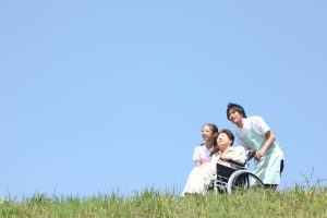 車椅子の高齢者と介護職