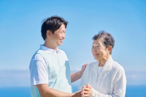 介護士と高齢者　屋外